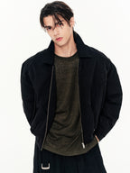 Person wearing a black jacket over a dark shirt on a white background
