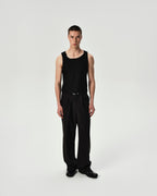 Person wearing a black tank top and pants on a white background