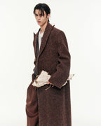 Person wearing a long brown coat on a white background